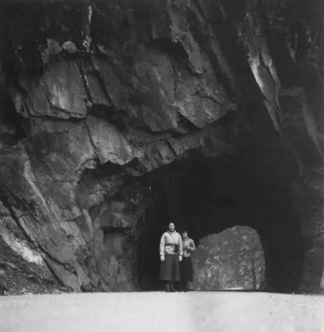 Frau führt jemanden aus Höhle